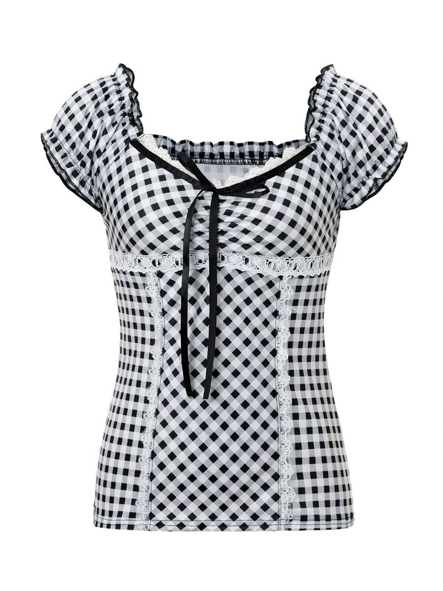 Women's black and white plaid short sleeve blouse featuring a tie-front front bow, contrast lace frill trim, raglan sleeves, and sweetheart neckline.