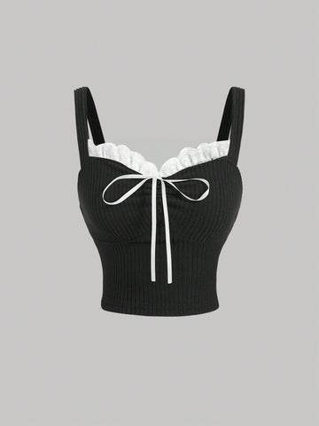 Black crop camisole top for women featuring shoulder straps, cold shoulder sleeves, drawstring detail, and frill trim on plain knitted fabric.