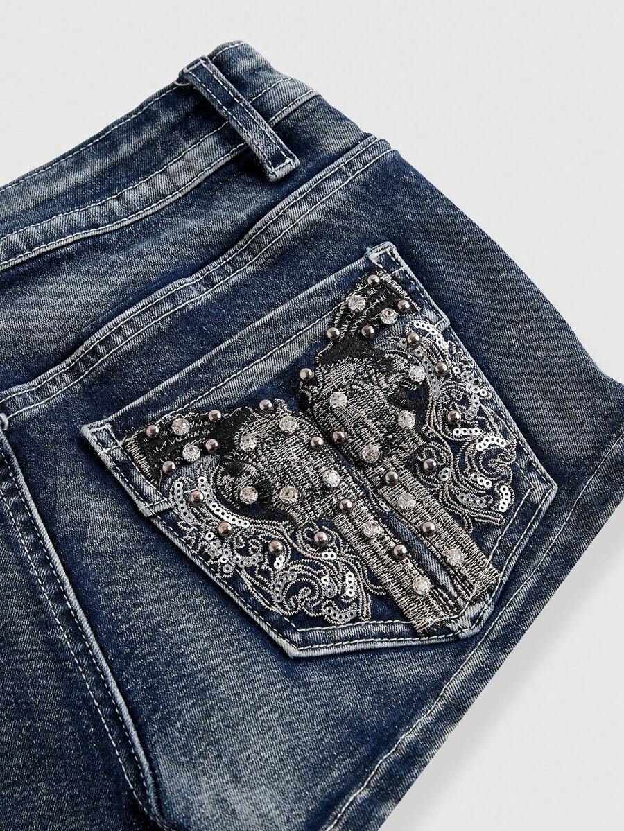 Women's ultra low waist skort with mini shorts length, zipper fly, pockets, pistol embroidery, and rhinestone details