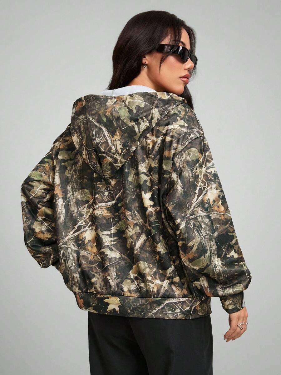 Women's army green camo zip up hoodie with drop shoulder sleeves, front pockets, and drawstring hood