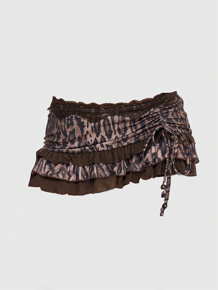 Women's black low-waist mini skirt with drawstring tie, ruched details, lace trim, layered ruffle hem, and asymmetric styling