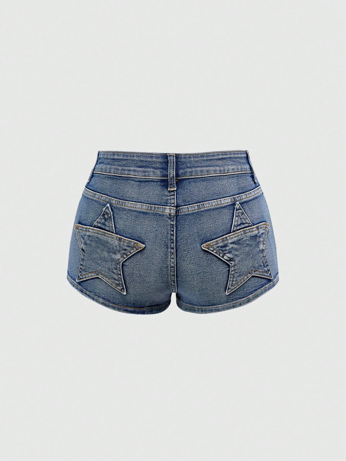 Women's ultra low waist mini shorts with back pockets, zipper fly, button detail, random print, and star patch in a grunge punk Y2K style.