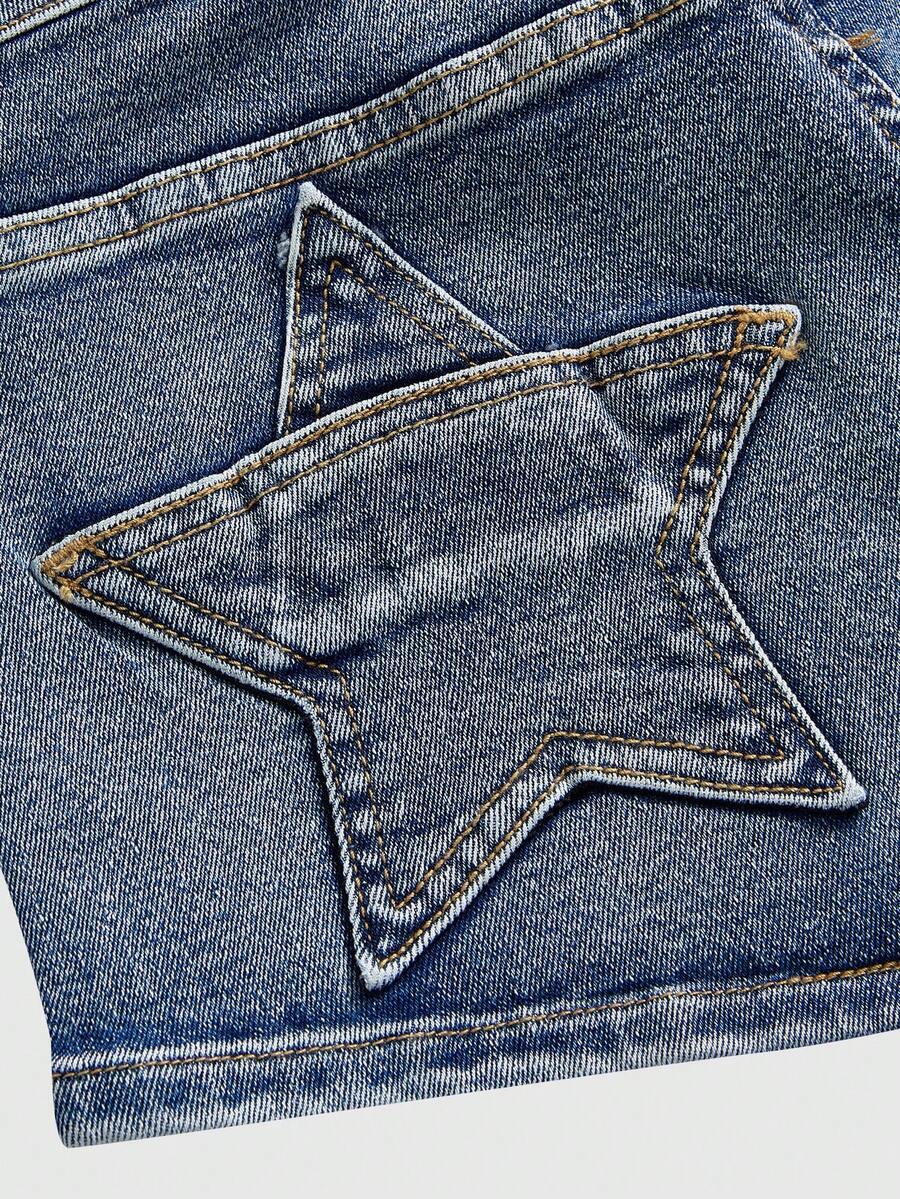 Women's ultra low waist mini shorts with back pockets, zipper fly, button detail, random print, and star patch in a grunge punk Y2K style.
