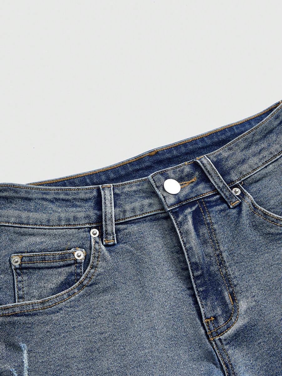 Women's ultra low waist mini shorts with back pockets, zipper fly, button detail, random print, and star patch in a grunge punk Y2K style.