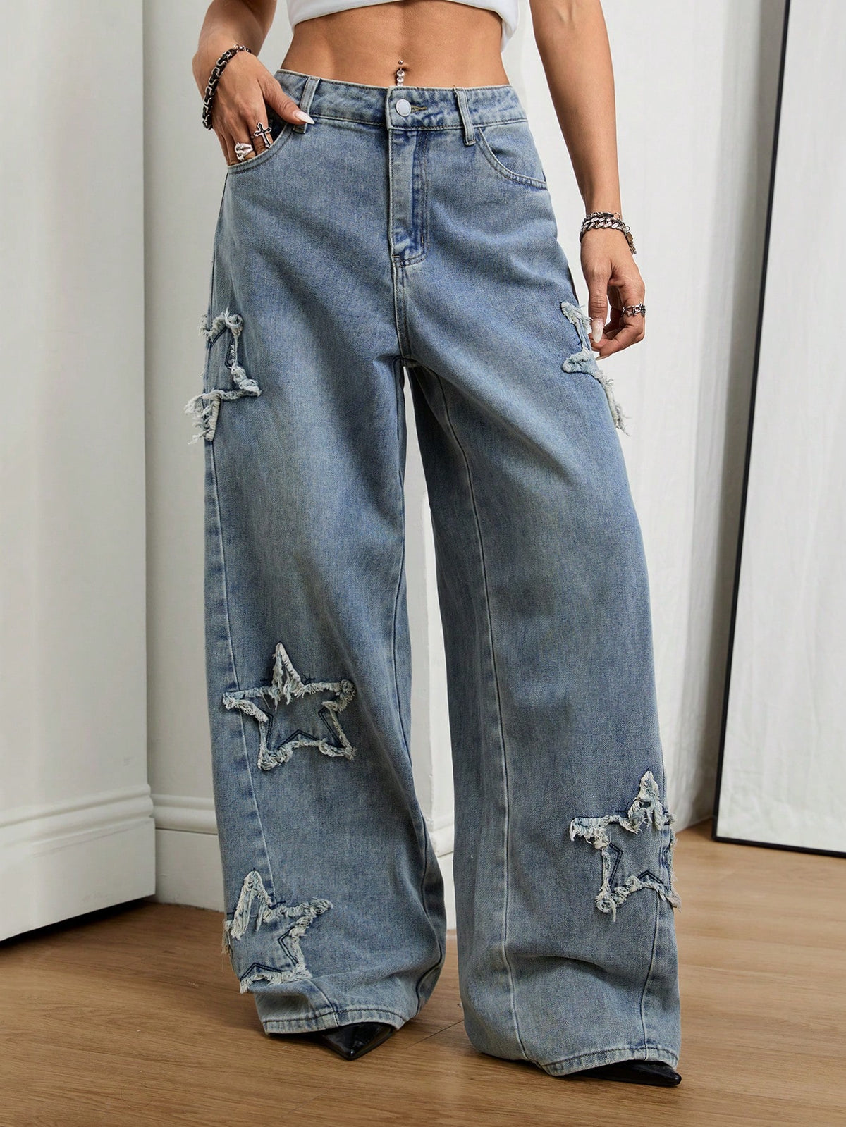 Front view of women's loose wide leg denim jeans featuring a mid waist, classic front pockets, and a zipper fly closure.