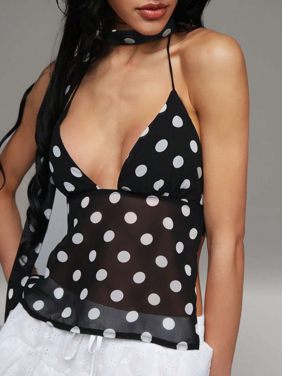 Women's black polka dot halter crop tank top with button front detail and asymmetrical hem.