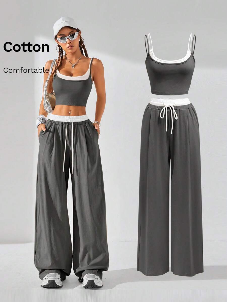 Dark grey women's two-piece outfit featuring a spaghetti strap cami crop top with contrast binding and matching wide-leg drawstring knit lounge pants.
