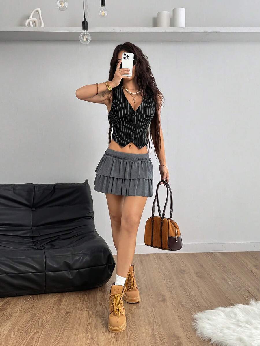 Women's striped sleeveless crop vest with V-neck, button-front closure, and asymmetrical hem.