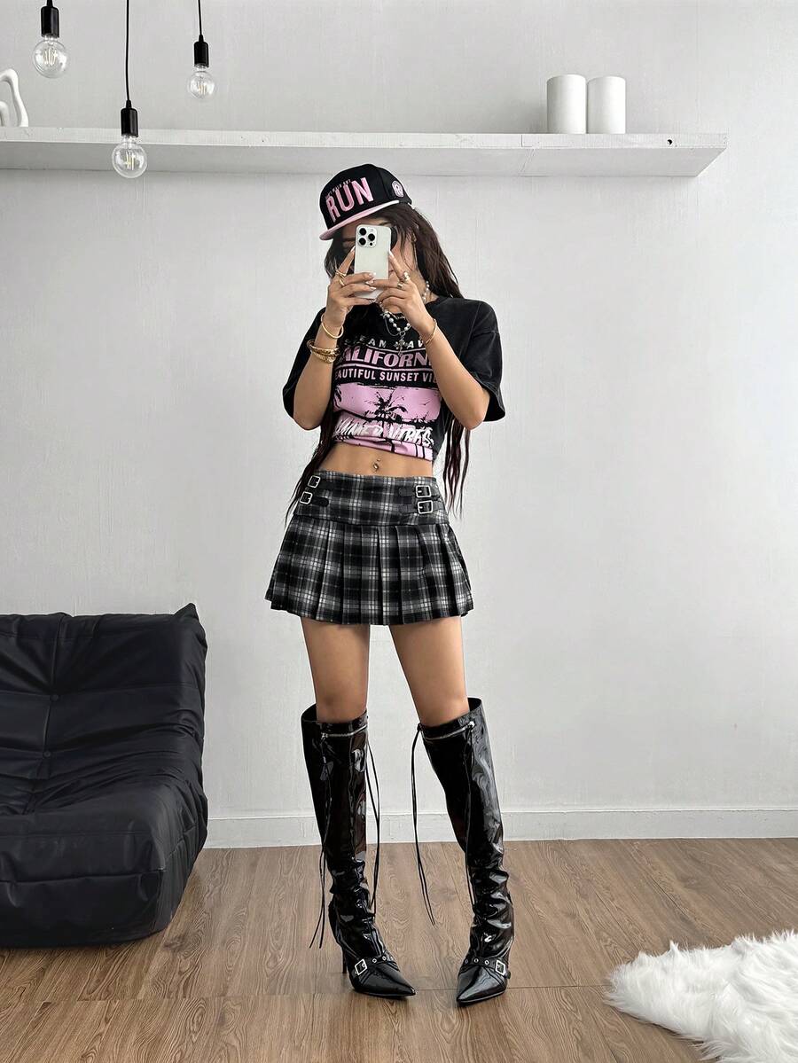 Women's black low waist pleated mini skirt featuring grommet eyelet accents and zipper closure