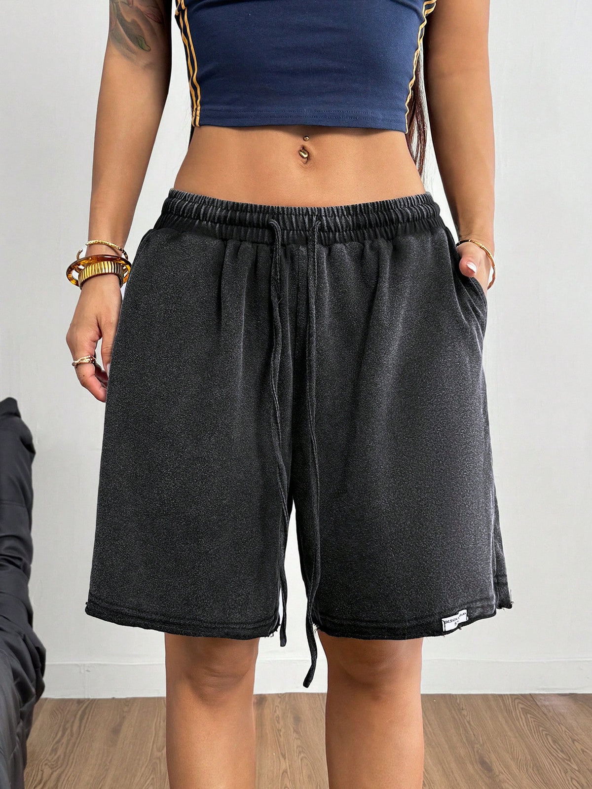 Women's loose fit dark grey track Bermuda shorts featuring an elastic drawstring waistband and side slit hem.