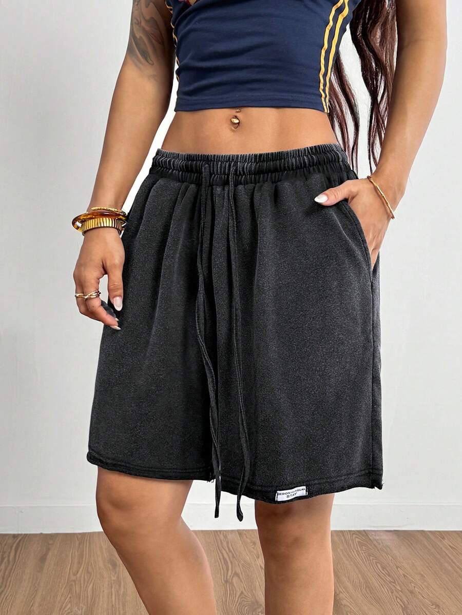 Women's loose fit dark grey track Bermuda shorts featuring an elastic drawstring waistband and side slit hem.