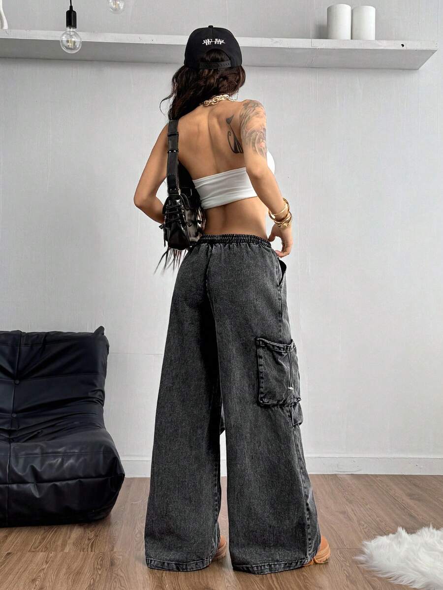 Women's black baggy cargo pants featuring a wide-leg cut, low-rise drawstring waist, and 100% cotton woven fabric.