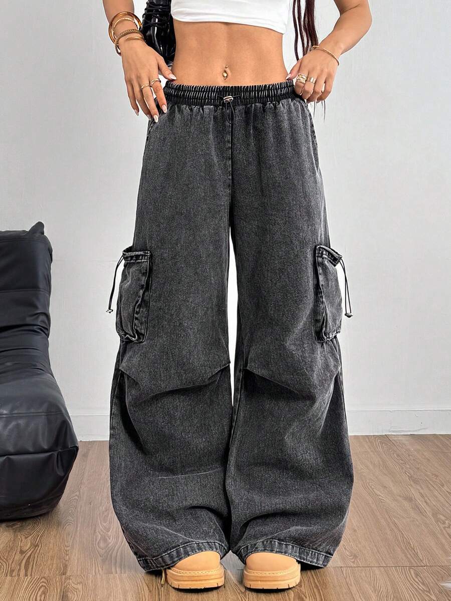 Women's black baggy cargo pants featuring a wide-leg cut, low-rise drawstring waist, and 100% cotton woven fabric.