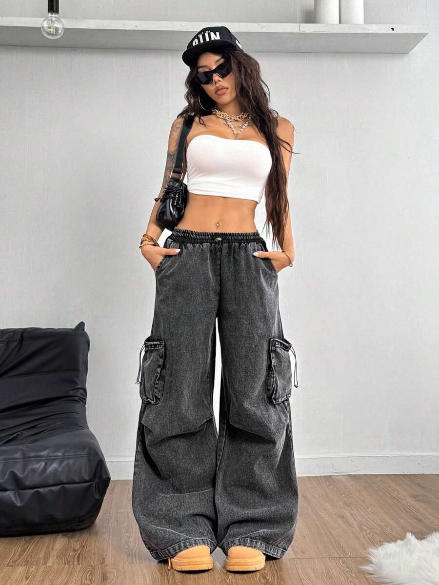 Women's black baggy cargo pants featuring a wide-leg cut, low-rise drawstring waist, and 100% cotton woven fabric.