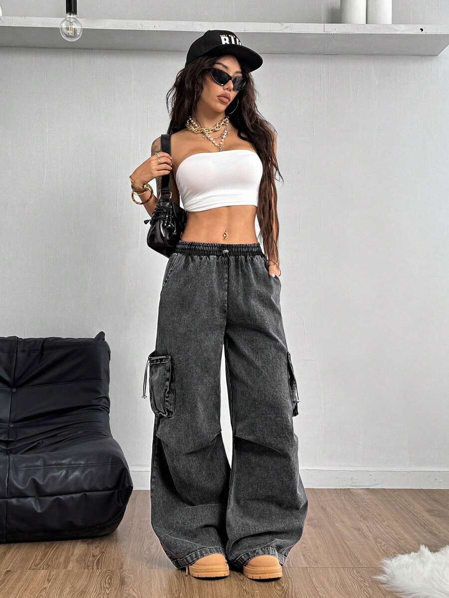 Women's black baggy cargo pants featuring a wide-leg cut, low-rise drawstring waist, and 100% cotton woven fabric.