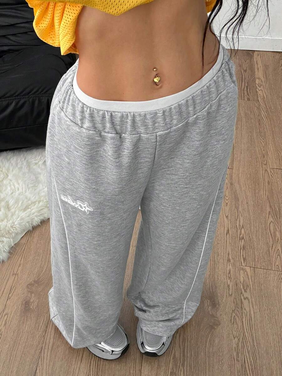 Grey patched baggy joggers with elastic mid-waist and loose straight leg fit