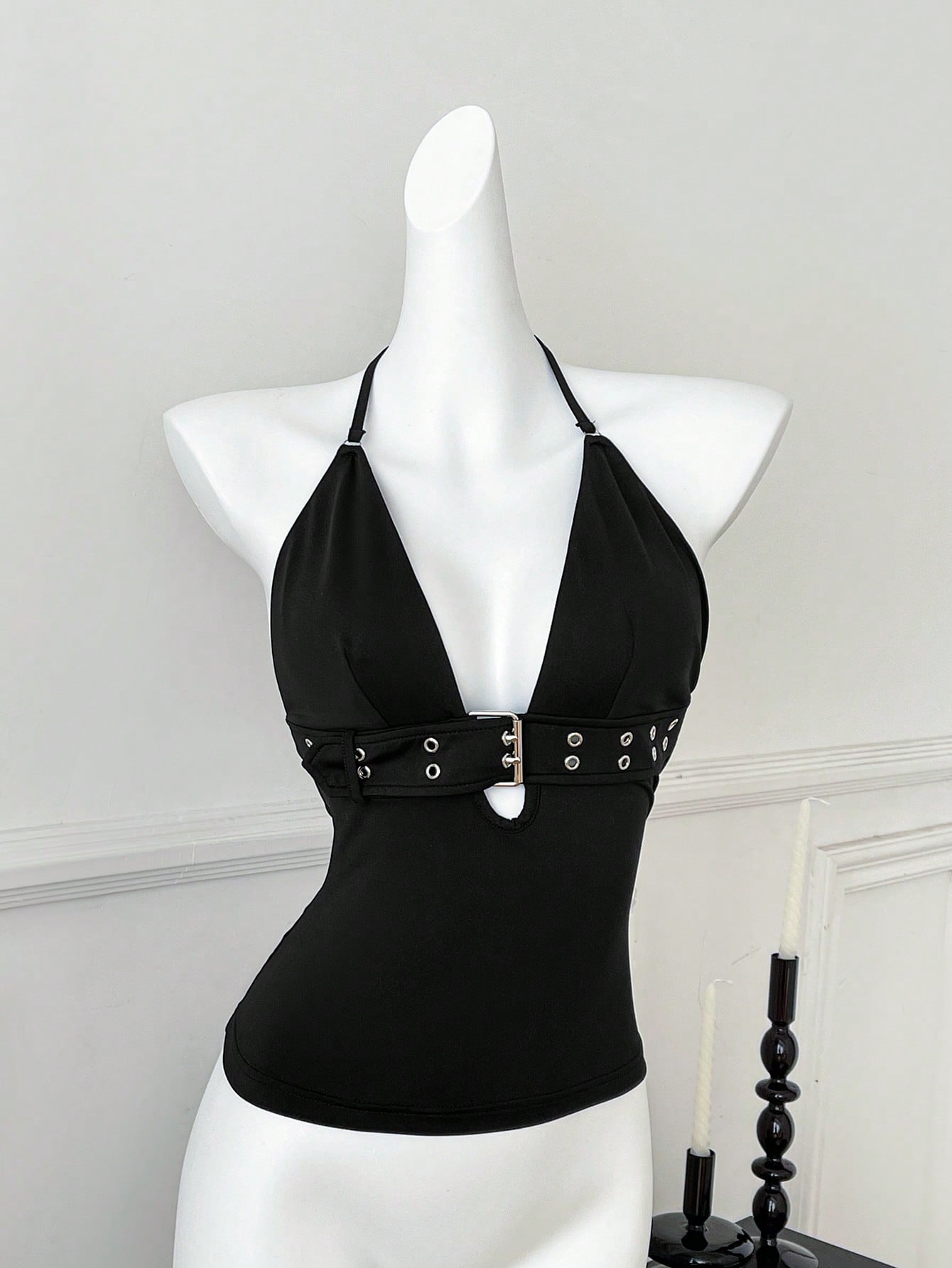 Women's black halter crop tank top with backless design, grommet eyelet detail, slim fit, and medium-stretch knitted fabric.