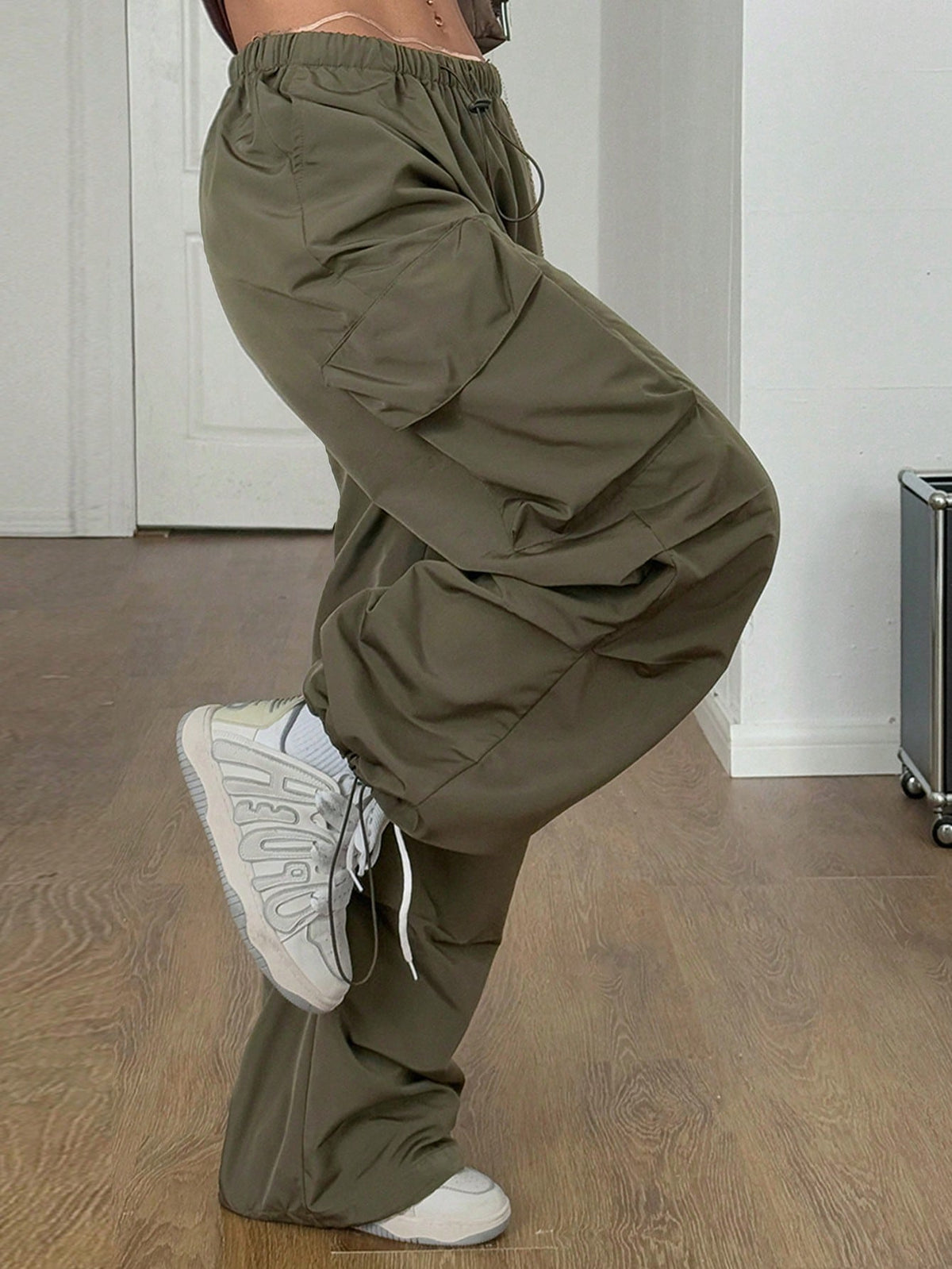 Women's loose fit parachute cargo pants featuring a drawstring waist and functional pockets in a casual streetwear style
