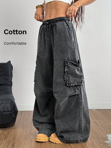 Women's black baggy cargo pants featuring a wide-leg cut, low-rise drawstring waist, and 100% cotton woven fabric.