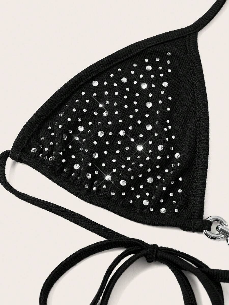 Women's slim fit halter crop top featuring a backless cut with knot and rhinestone accents.