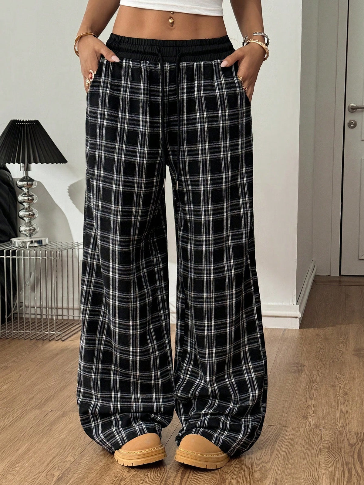 Women's casual black and white checked wide leg pants featuring an elastic drawstring waistband and a loose straight leg fit.
