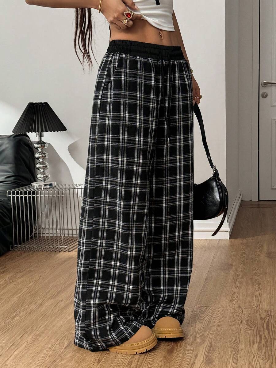 Women's casual black and white checked wide leg pants featuring an elastic drawstring waistband and a loose straight leg fit.