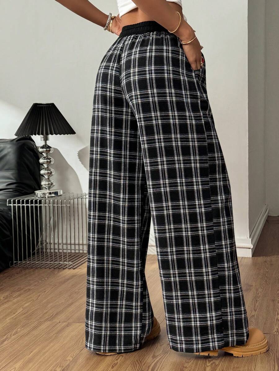 Women's casual black and white checked wide leg pants featuring an elastic drawstring waistband and a loose straight leg fit.