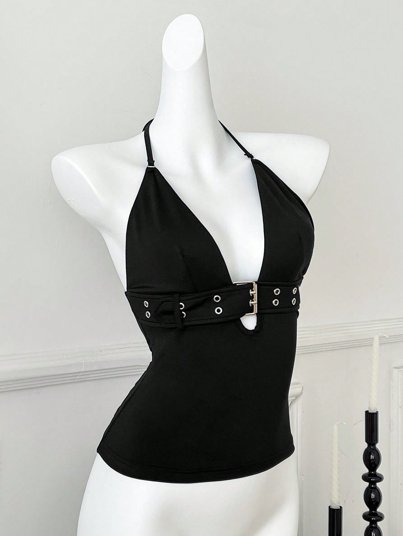 Women's black halter crop tank top with backless design, grommet eyelet detail, slim fit, and medium-stretch knitted fabric.