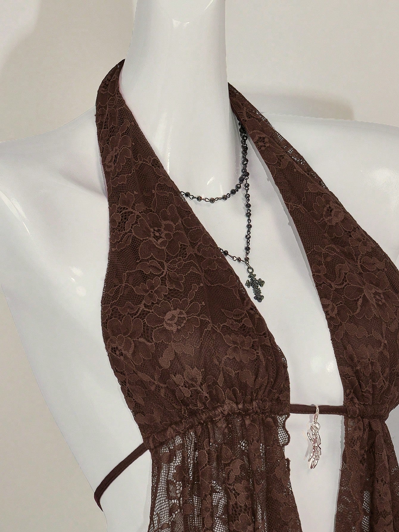 Women's lace halter neck camisole with backless styling, asymmetrical hem, slim fit, and semi-sheer lined design