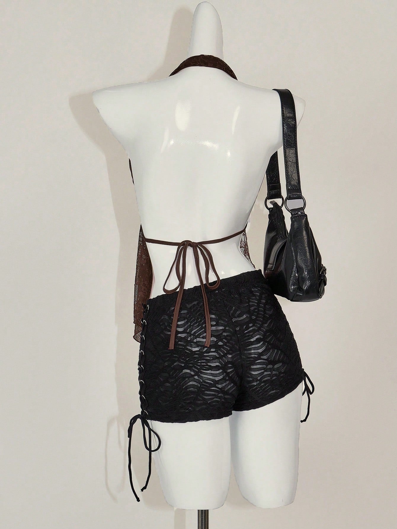 Women's lace halter neck camisole with backless styling, asymmetrical hem, slim fit, and semi-sheer lined design