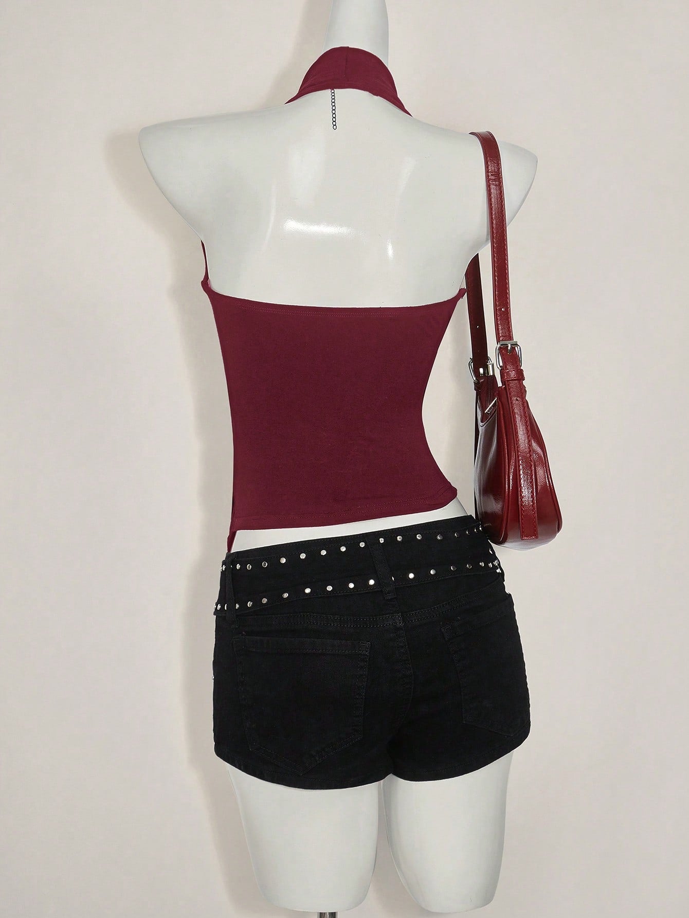 Women's asymmetrical hem halter tank top with draped neckline, backless wrap styling, and grommet eyelet details