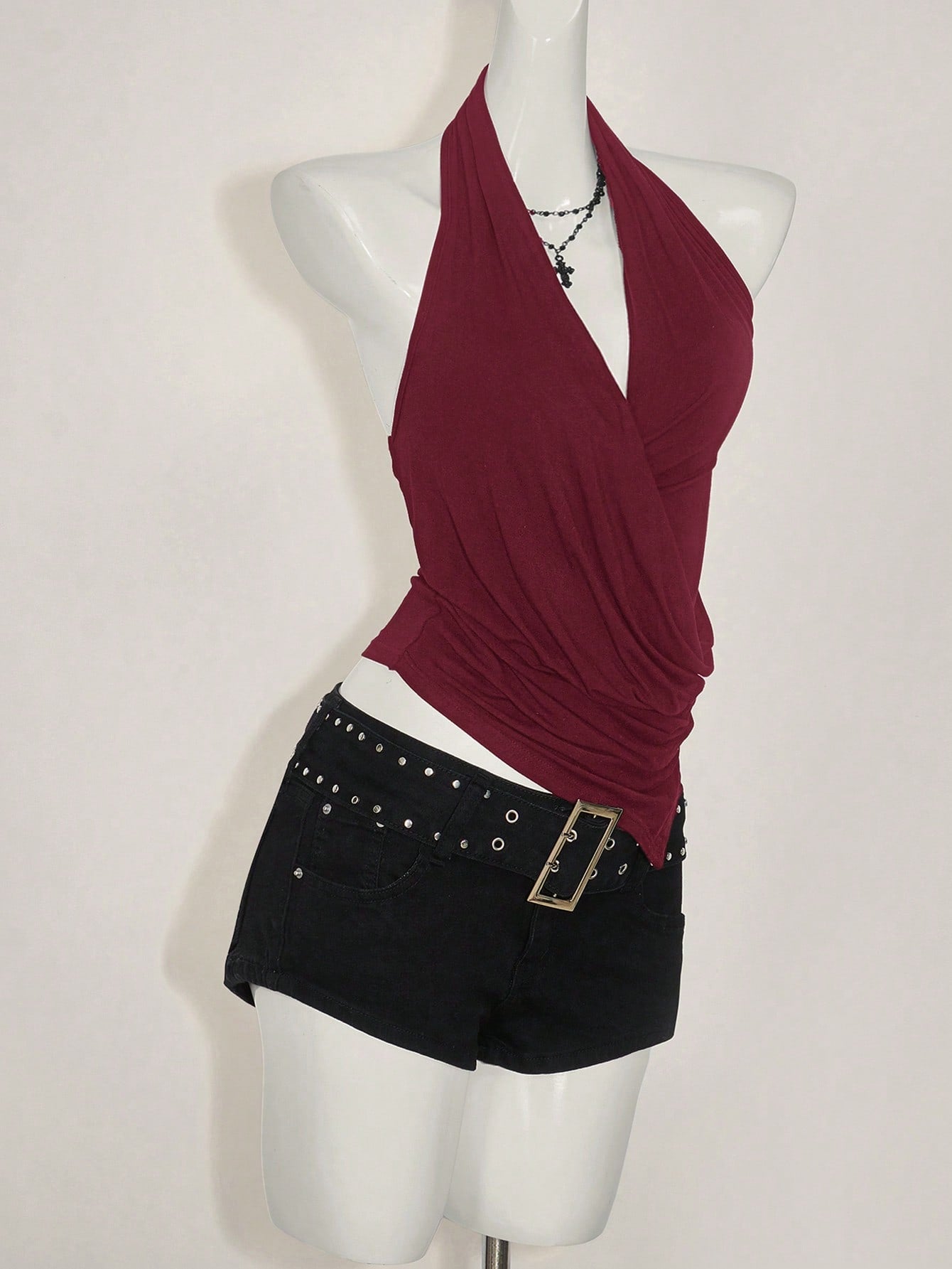 Women's asymmetrical hem halter tank top with draped neckline, backless wrap styling, and grommet eyelet details