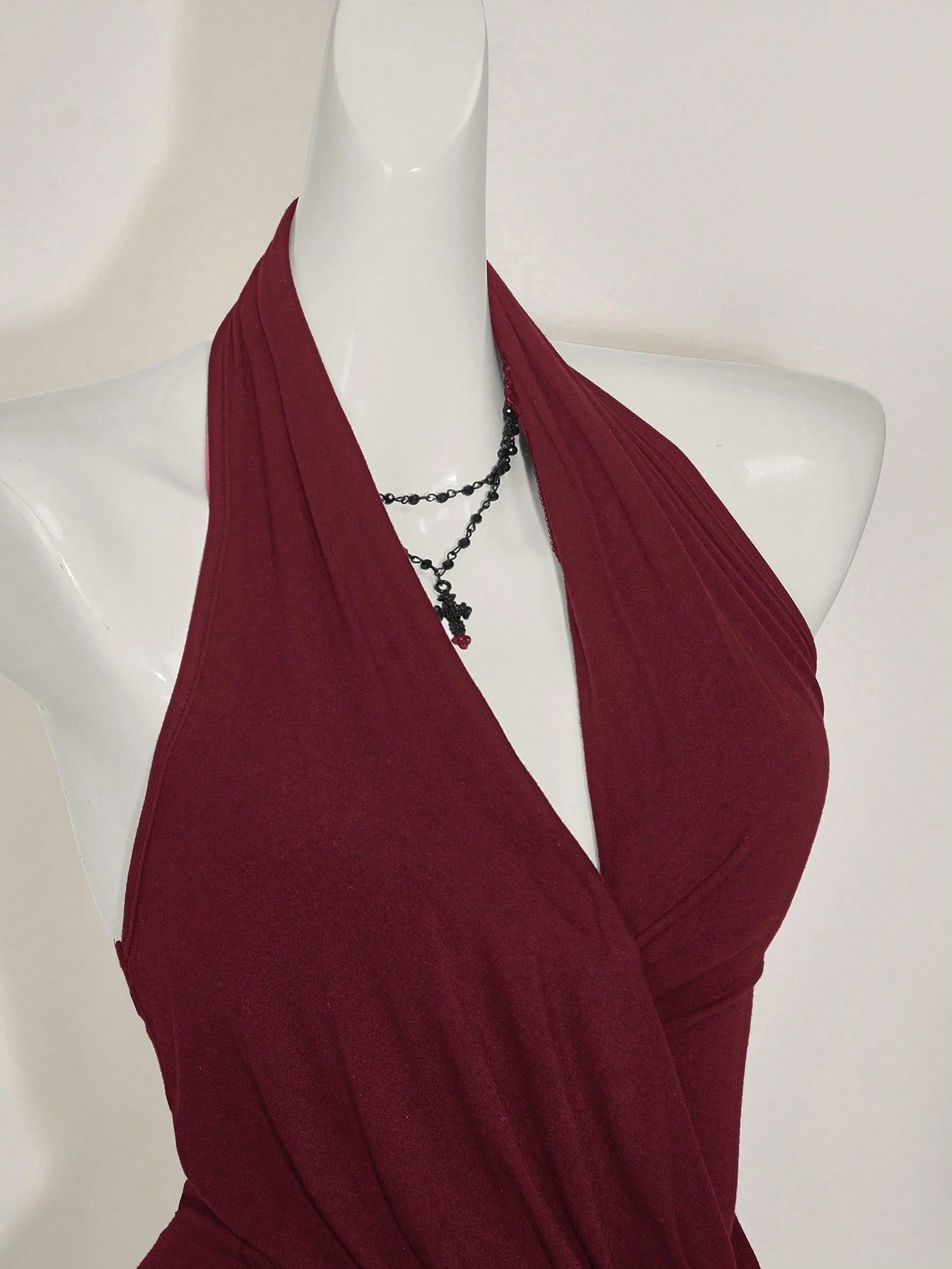 Women's asymmetrical hem halter tank top with draped neckline, backless wrap styling, and grommet eyelet details