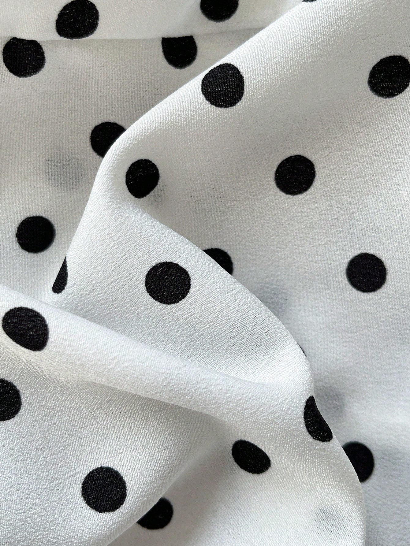 Women's polka dot halter camisole with bow bust detail, ruched and shirred design, slim crop fit, and flared ruffle hem.