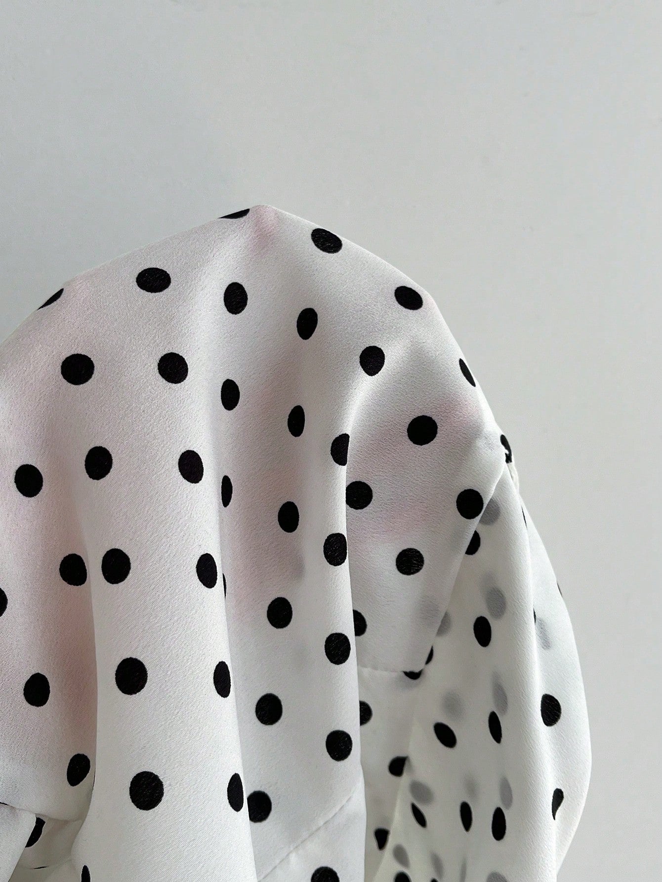 Women's polka dot halter camisole with bow bust detail, ruched and shirred design, slim crop fit, and flared ruffle hem.
