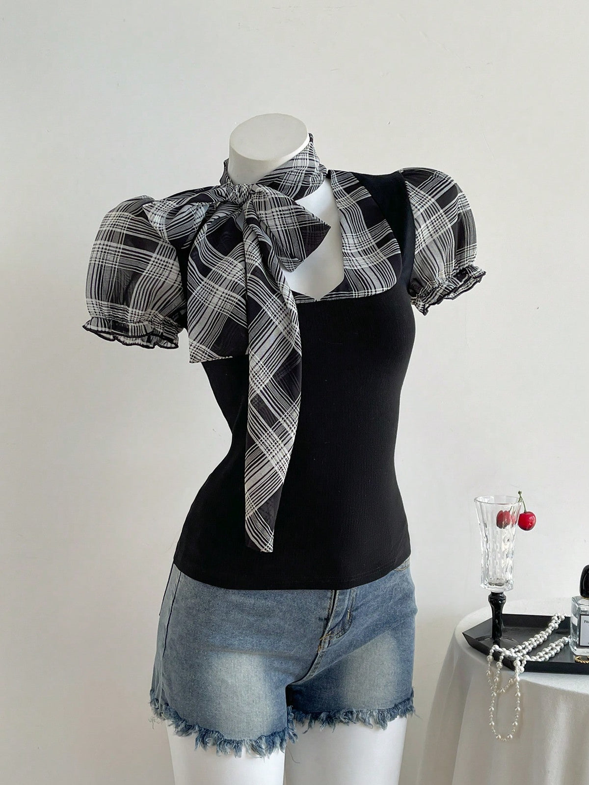 Women's slim fit short sleeve t-shirt featuring puff sleeves, Queen Anne neckline, tie-up front knot, frill detail, and raw hem.