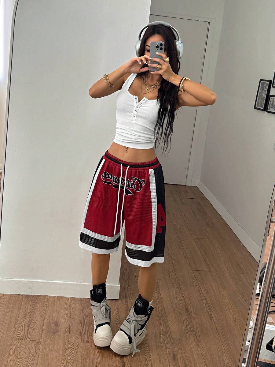Women's black and white breathable mesh basketball shorts featuring a drawstring waist, side stripe detailing, and loose Bermuda cut.