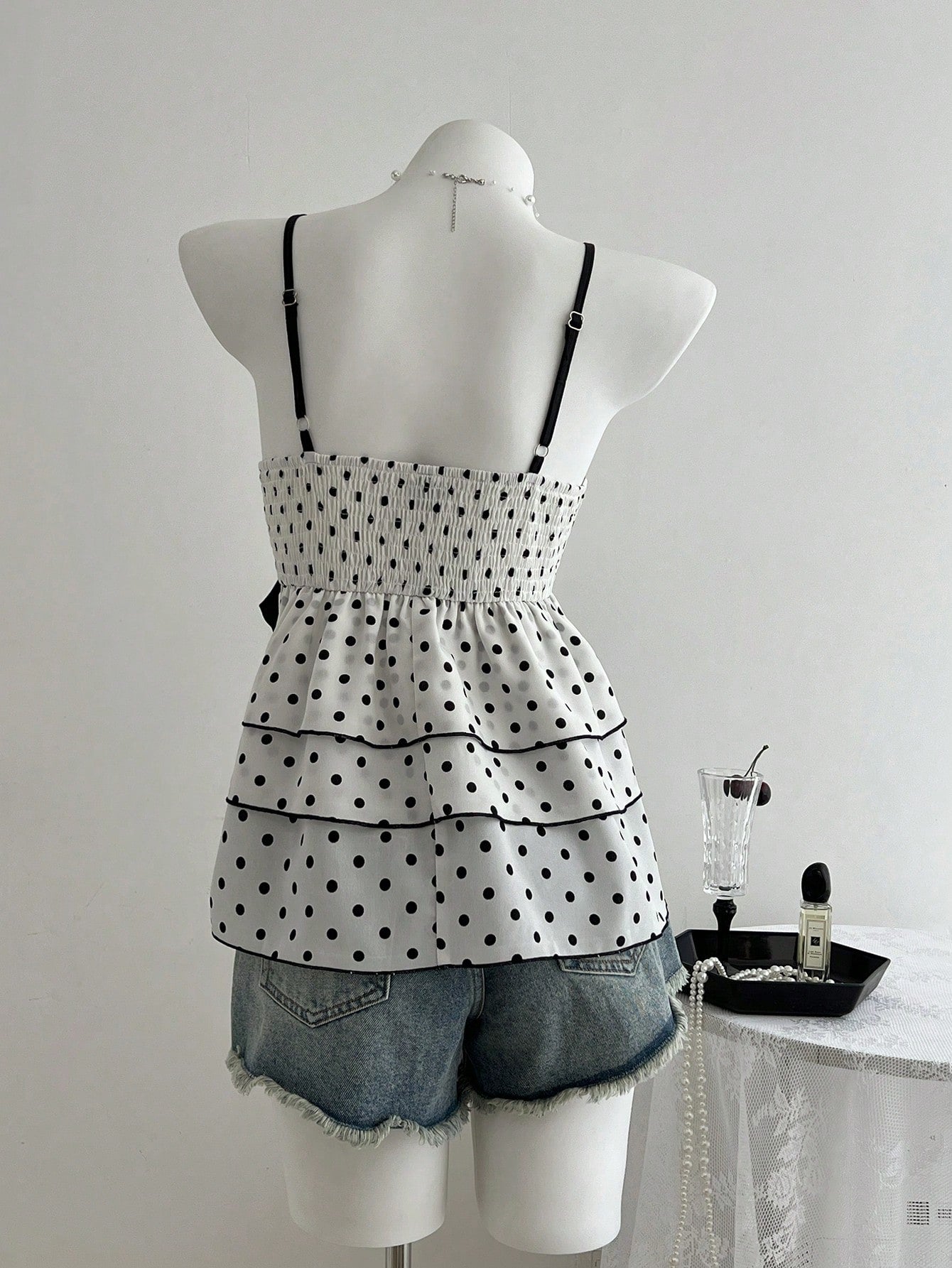 Women's polka dot camisole top with contrast lace trim, tank vest neckline, slim fit, and flared ruffle hem.