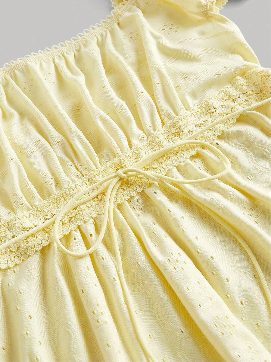 Yellow short puff sleeve tee featuring a square neckline, ruched bust with knot detail, eyelet embroidery, and a gathered waist.