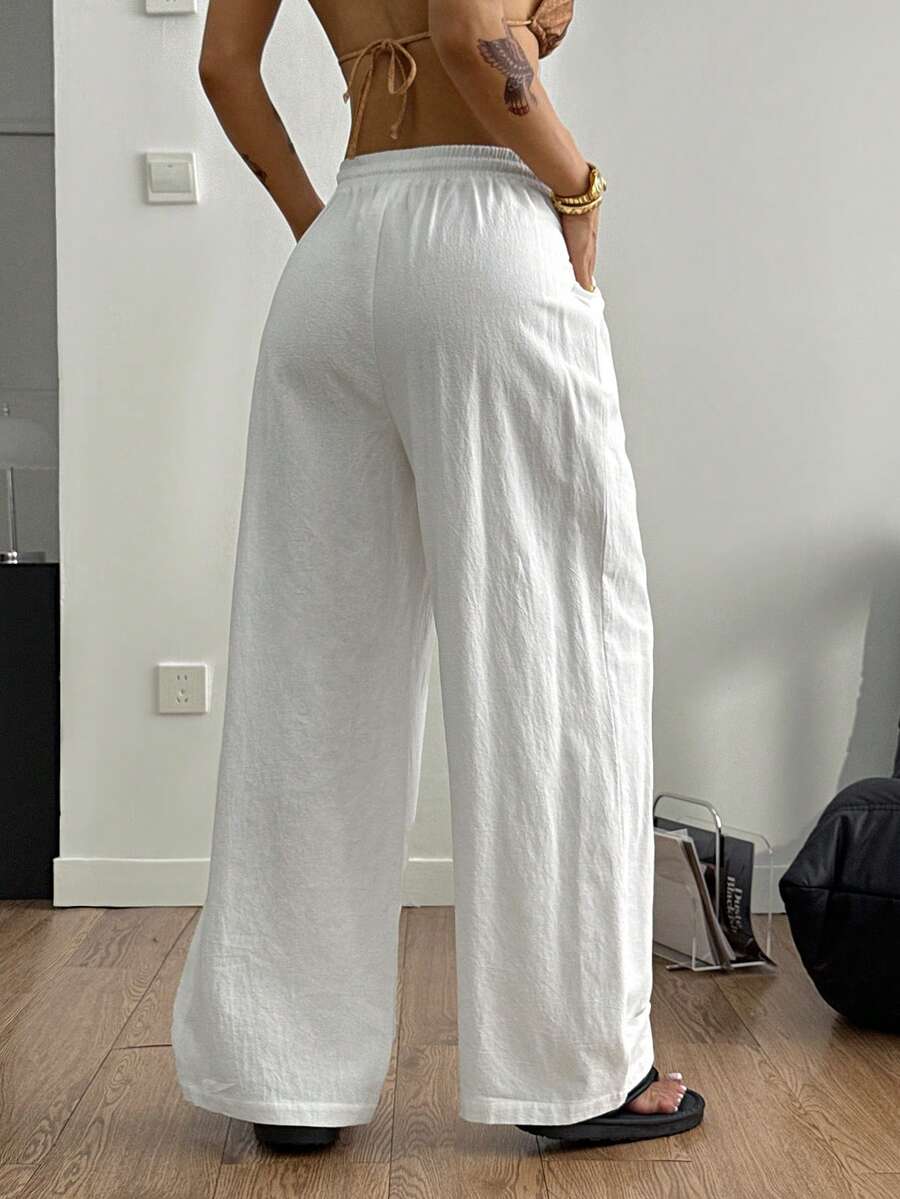 Women's loose fit brown and tan plaid wide leg pants featuring an elastic drawstring waist and side pockets.