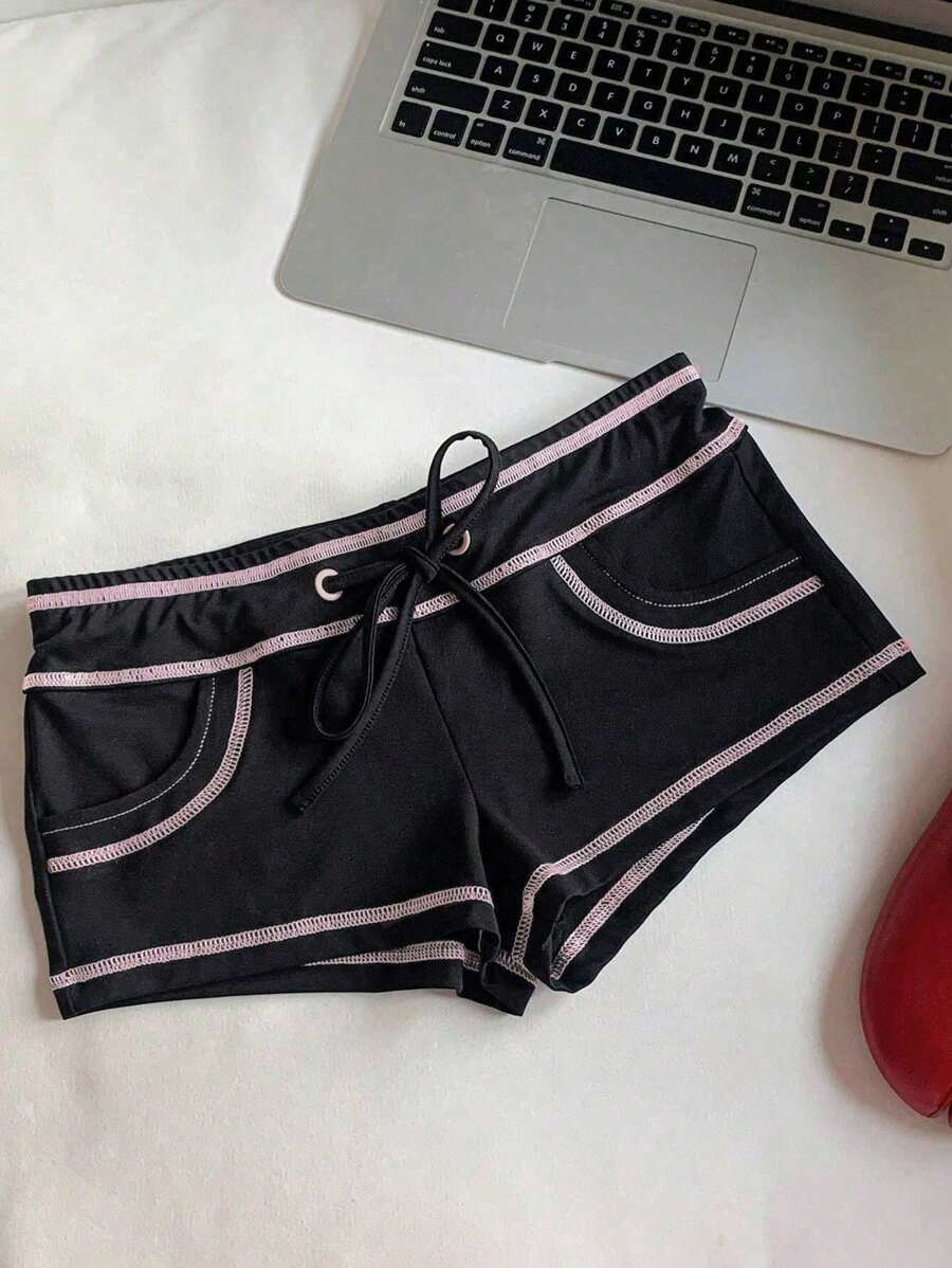 Women's low waist track shorts with drawstring waist, zipper detail, and mini length in a casual skinny fit