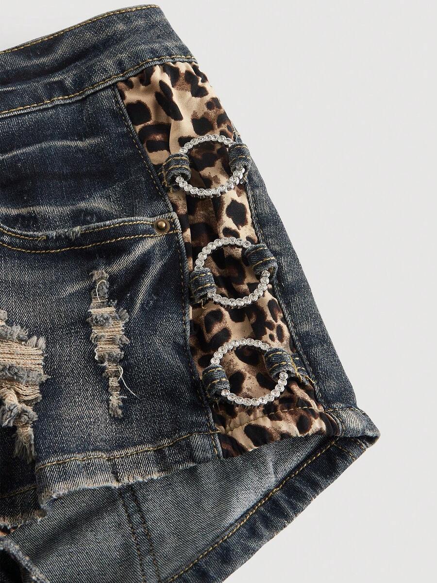 Women's ultra low waist vintage Y2K leopard print skinny mini shorts featuring ripped details, button, and zipper fly.