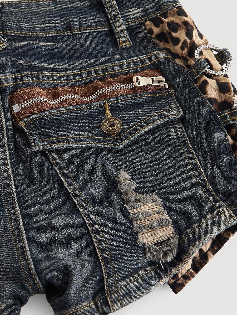 Women's ultra low waist vintage Y2K leopard print skinny mini shorts featuring ripped details, button, and zipper fly.