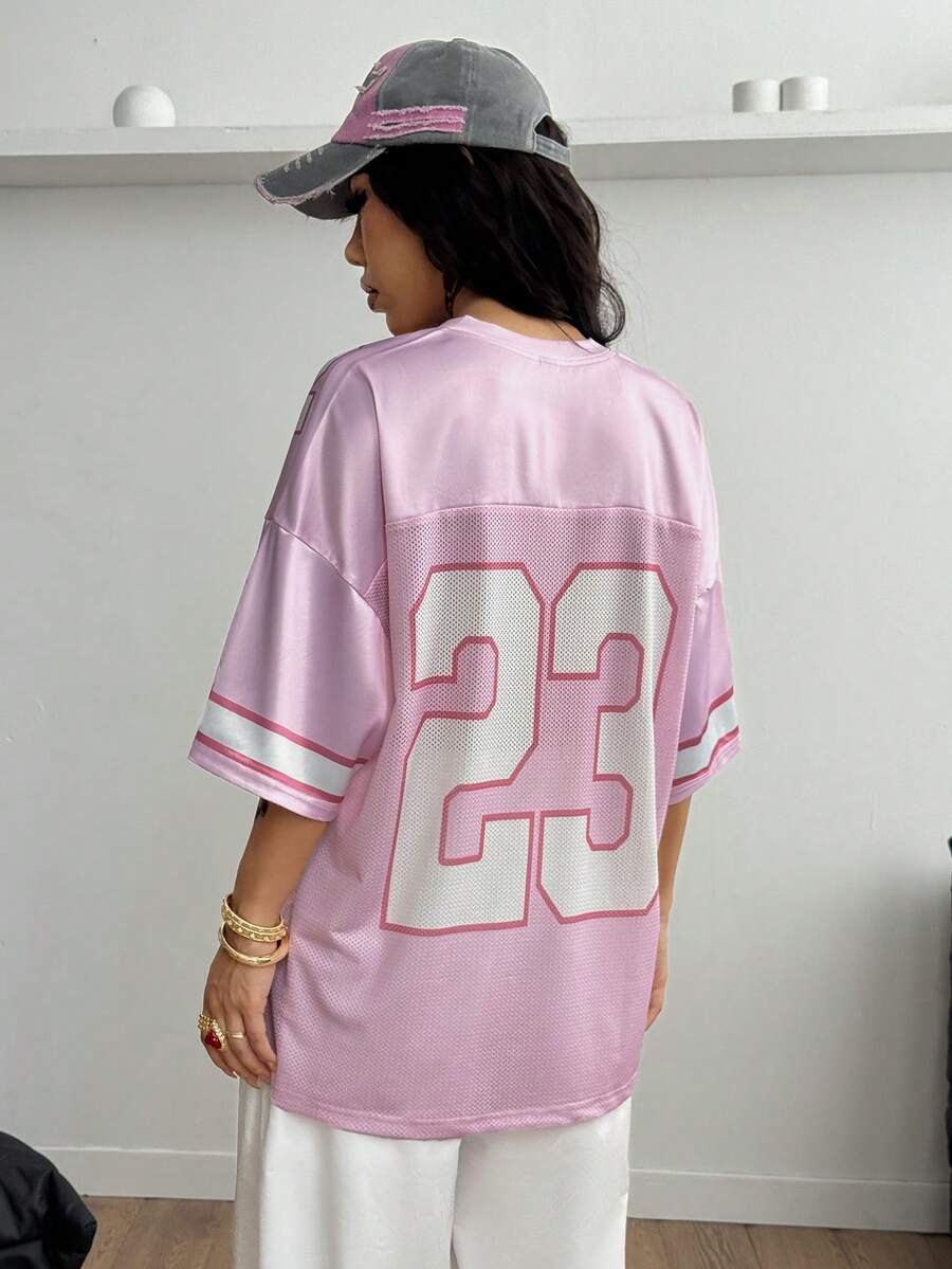 Oversized short-sleeve football jersey top featuring a V-neckline, contrast binding, and graphic number print.