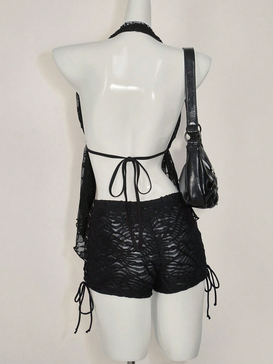 Women's lace halter neck camisole with backless styling, asymmetrical hem, slim fit, and semi-sheer lined design