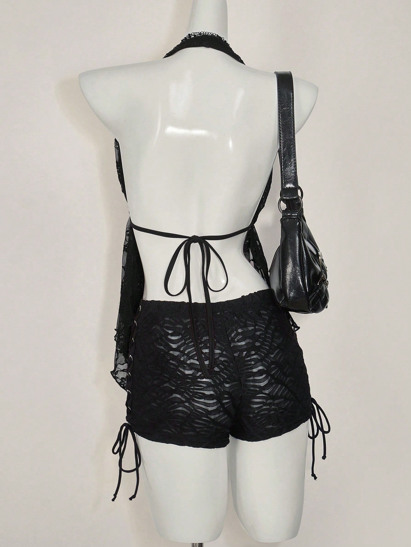 Women's lace halter neck camisole with backless styling, asymmetrical hem, slim fit, and semi-sheer lined design