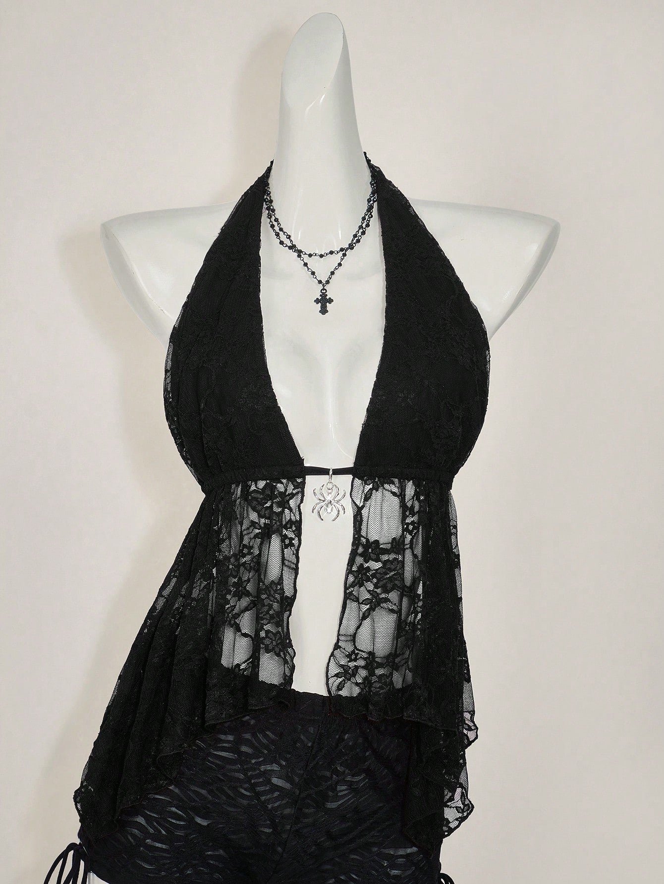 Women's lace halter neck camisole with backless styling, asymmetrical hem, slim fit, and semi-sheer lined design