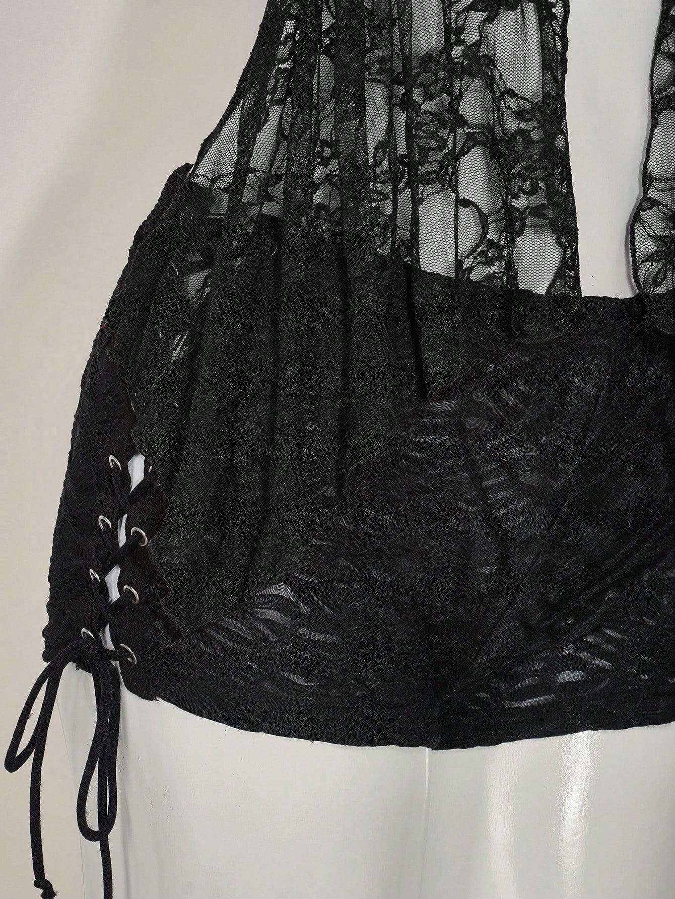 Women's lace halter neck camisole with backless styling, asymmetrical hem, slim fit, and semi-sheer lined design
