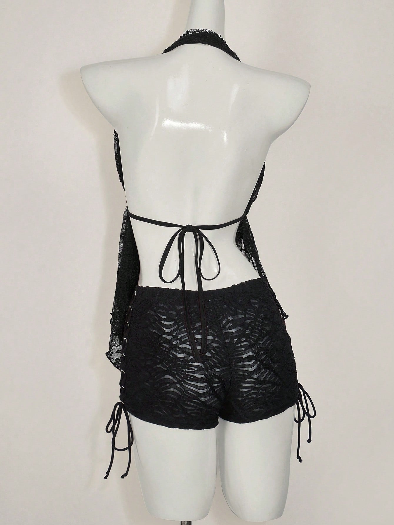 Women's lace halter neck camisole with backless styling, asymmetrical hem, slim fit, and semi-sheer lined design