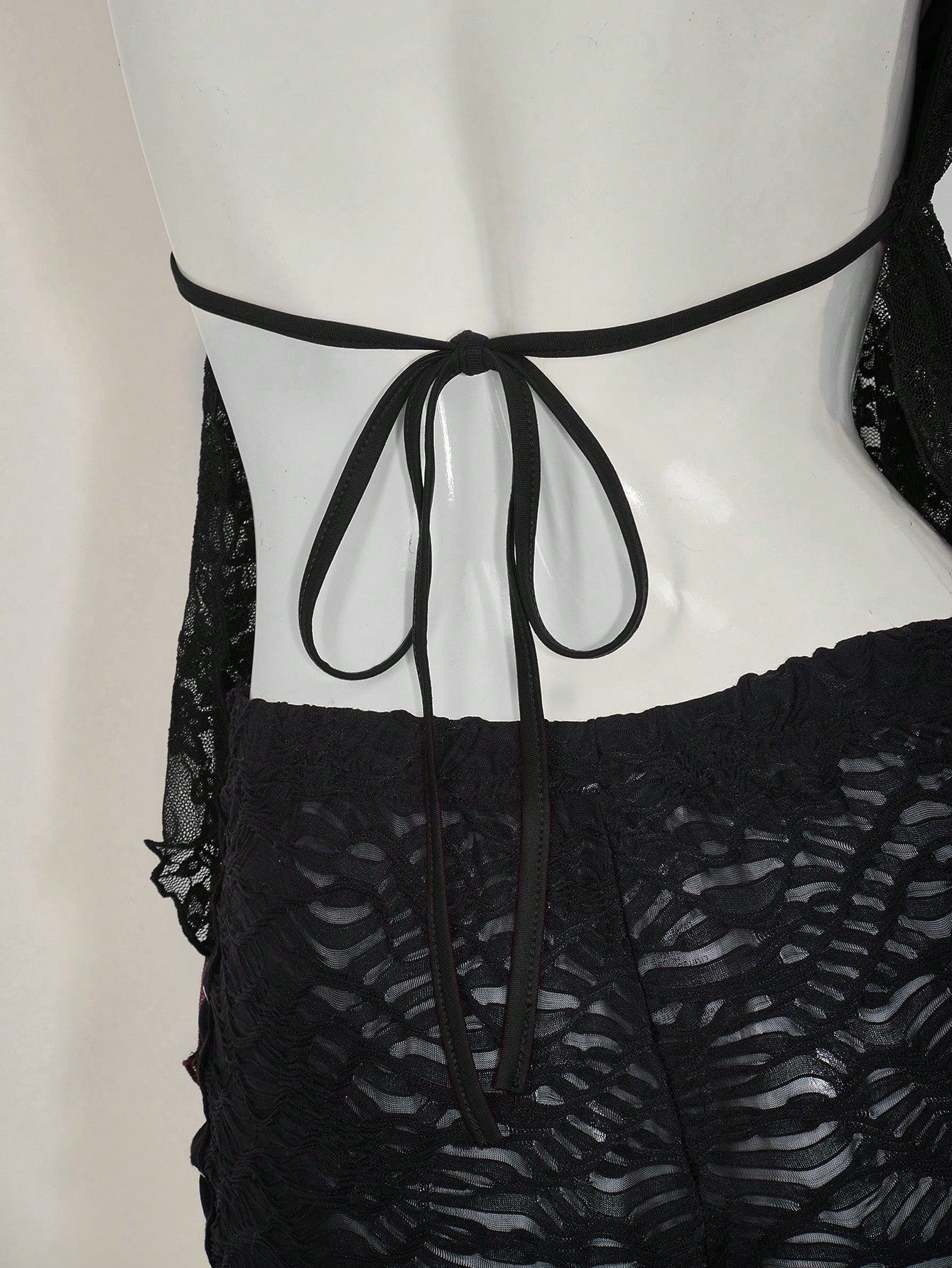 Women's lace halter neck camisole with backless styling, asymmetrical hem, slim fit, and semi-sheer lined design